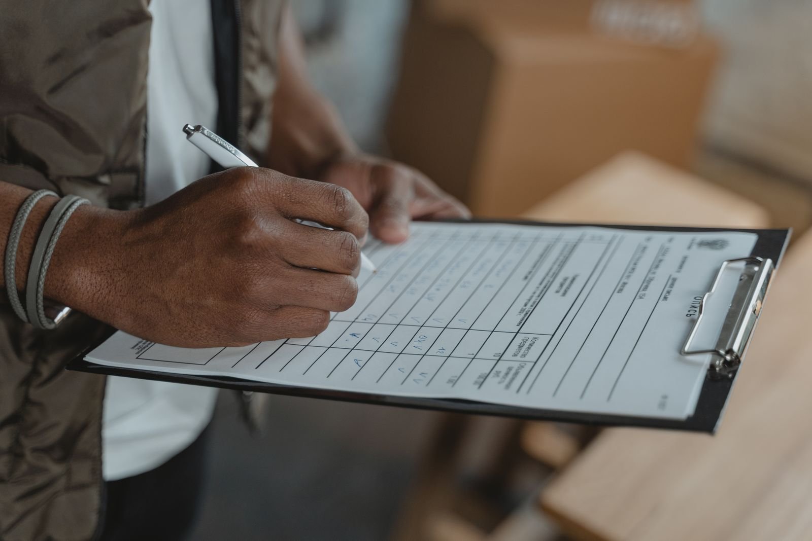 Detailing shop staff member reviewing a booking schedule on a clipboard