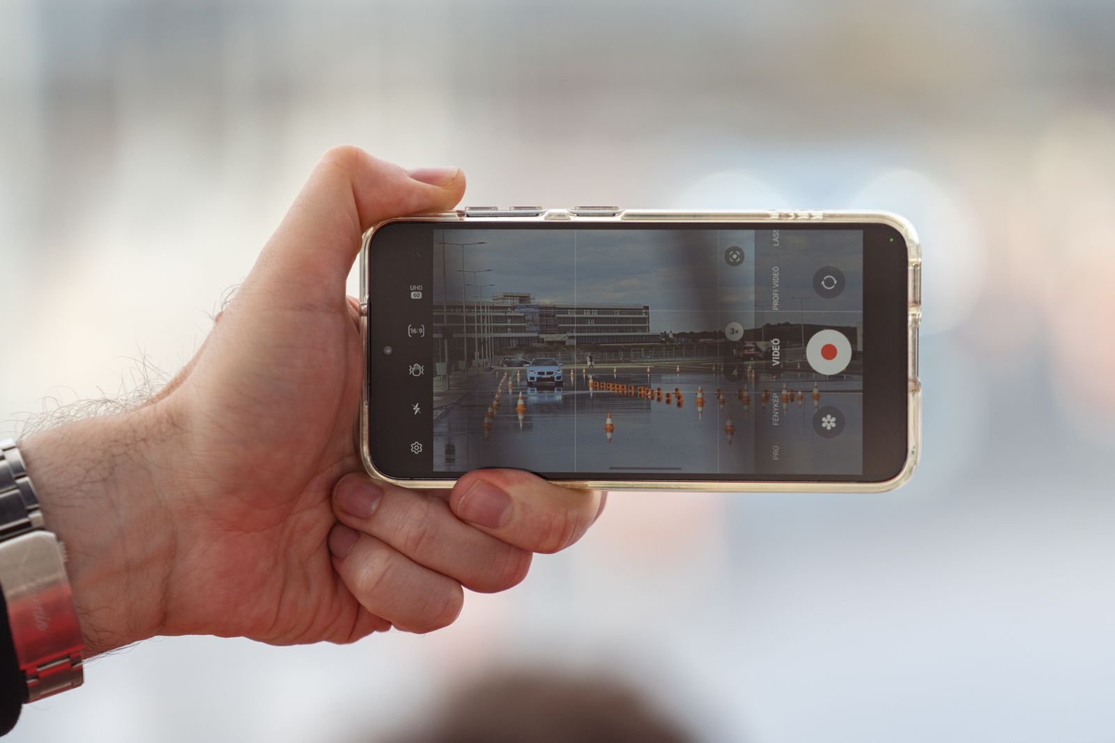 Hand holding a smartphone recording a short video of a car for a Facebook ad
