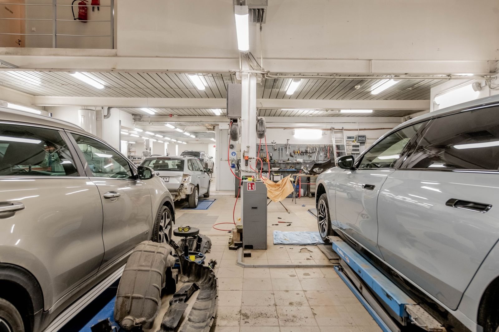 Auto body repair shop interior with vehicles in service bays