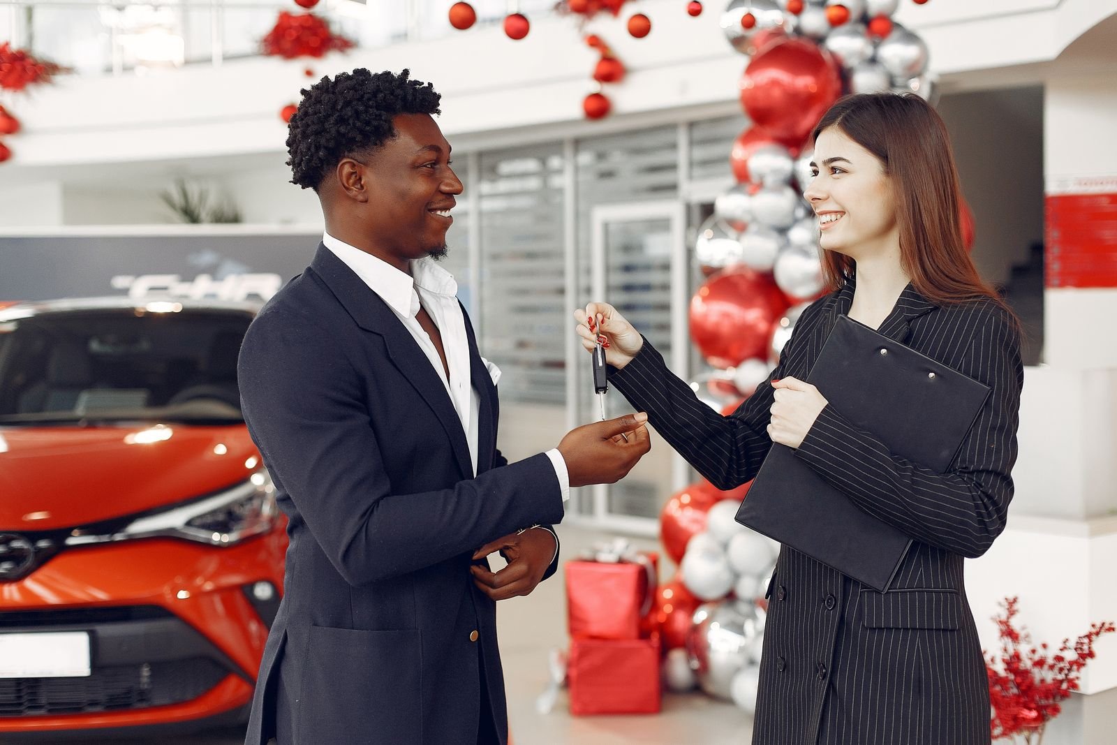 Detailing shop staff handing car keys back to a returning customer in Florida