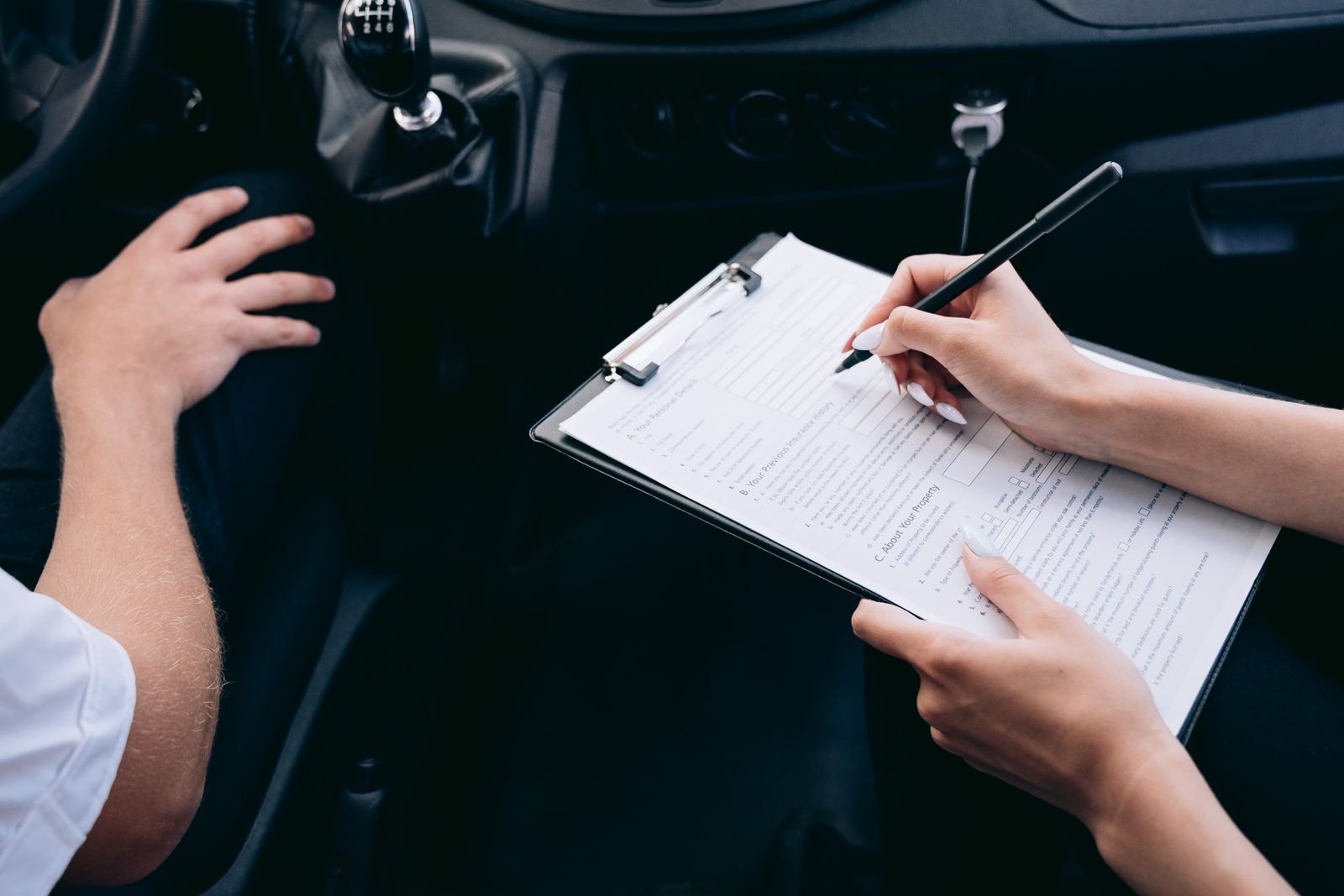 Person documenting an insurance claim inside a damaged vehicle in Florida