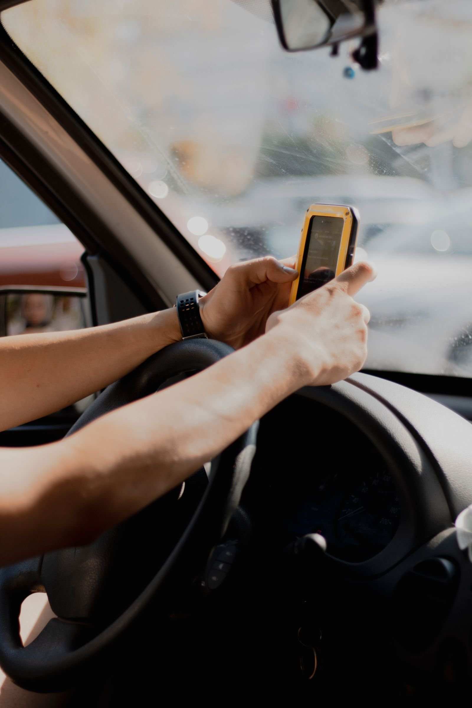 Driver using a smartphone to search for a collision repair shop after an accident