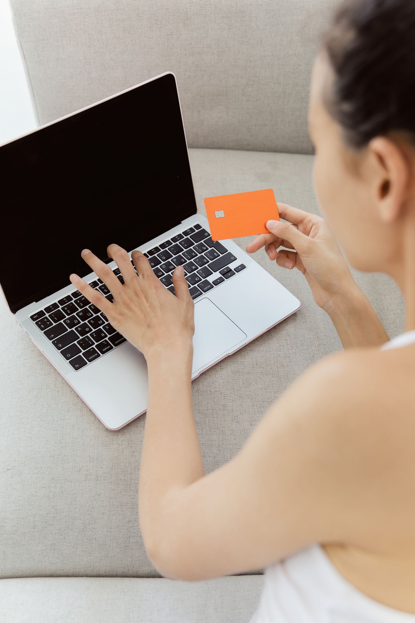 Customer using a laptop and card to buy auto parts online by VIN