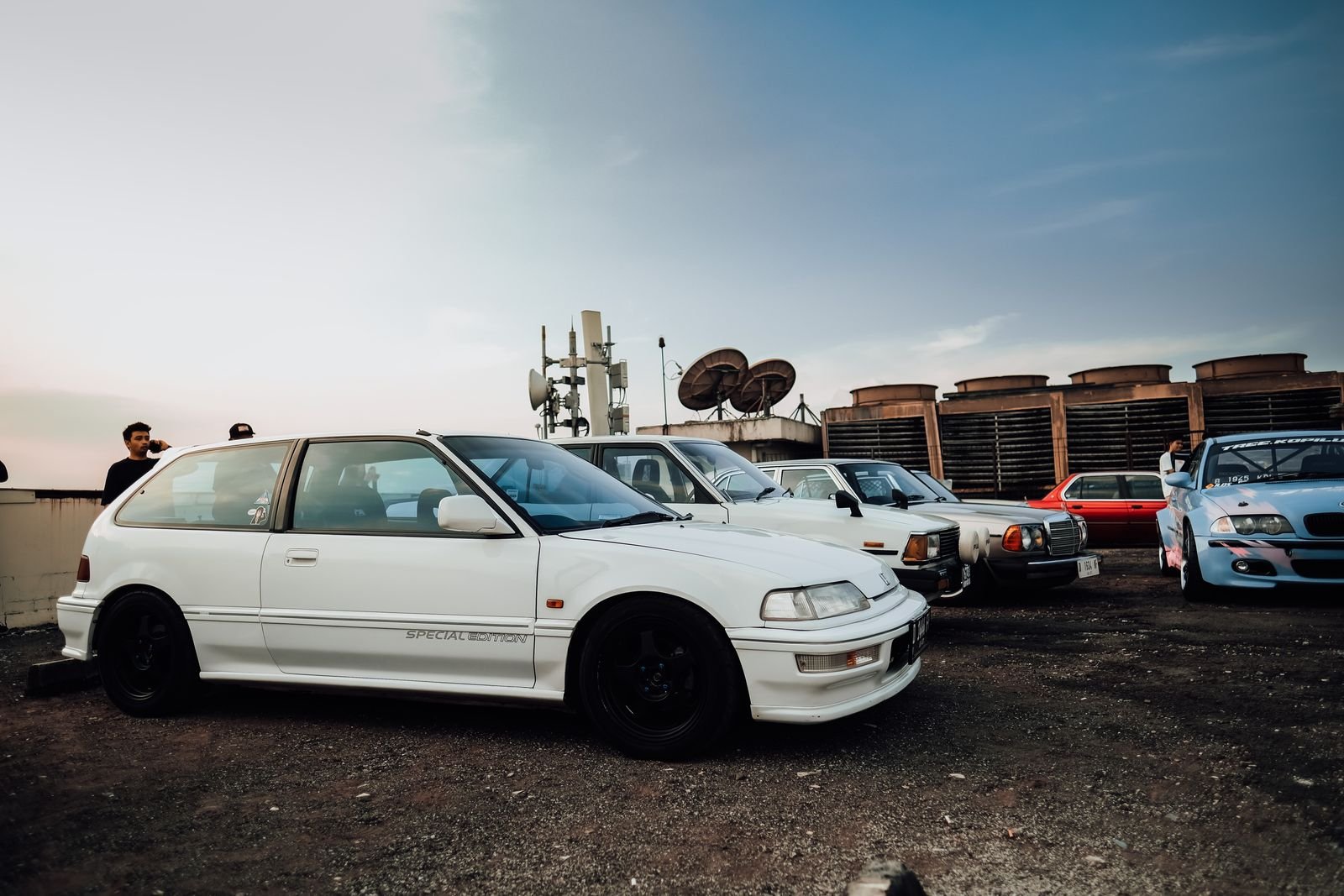 Car enthusiasts gathered at an outdoor car club meetup in Florida