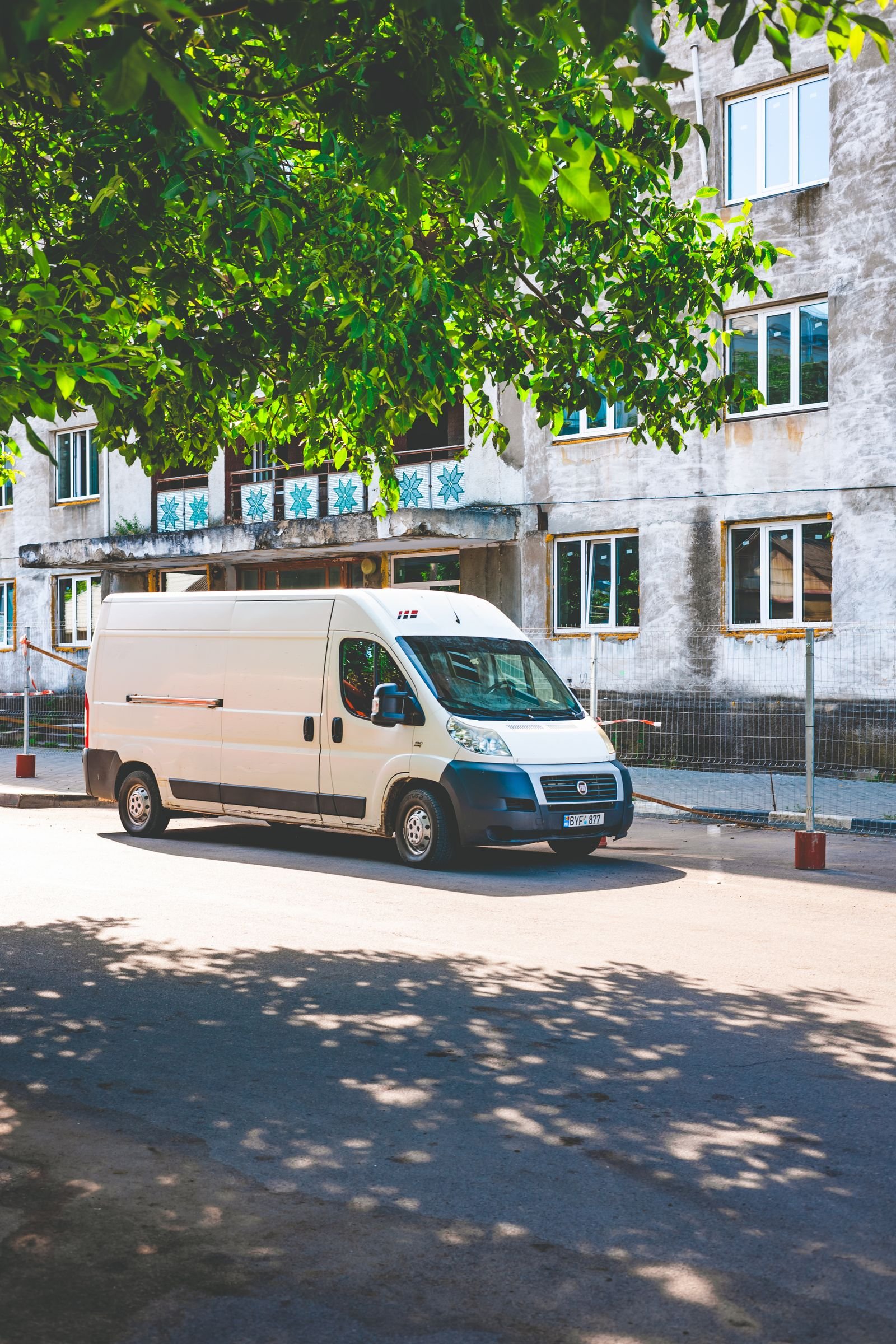 White delivery van driving on a sunny street, an example of vehicle wrap marketing in Orlando Florida
