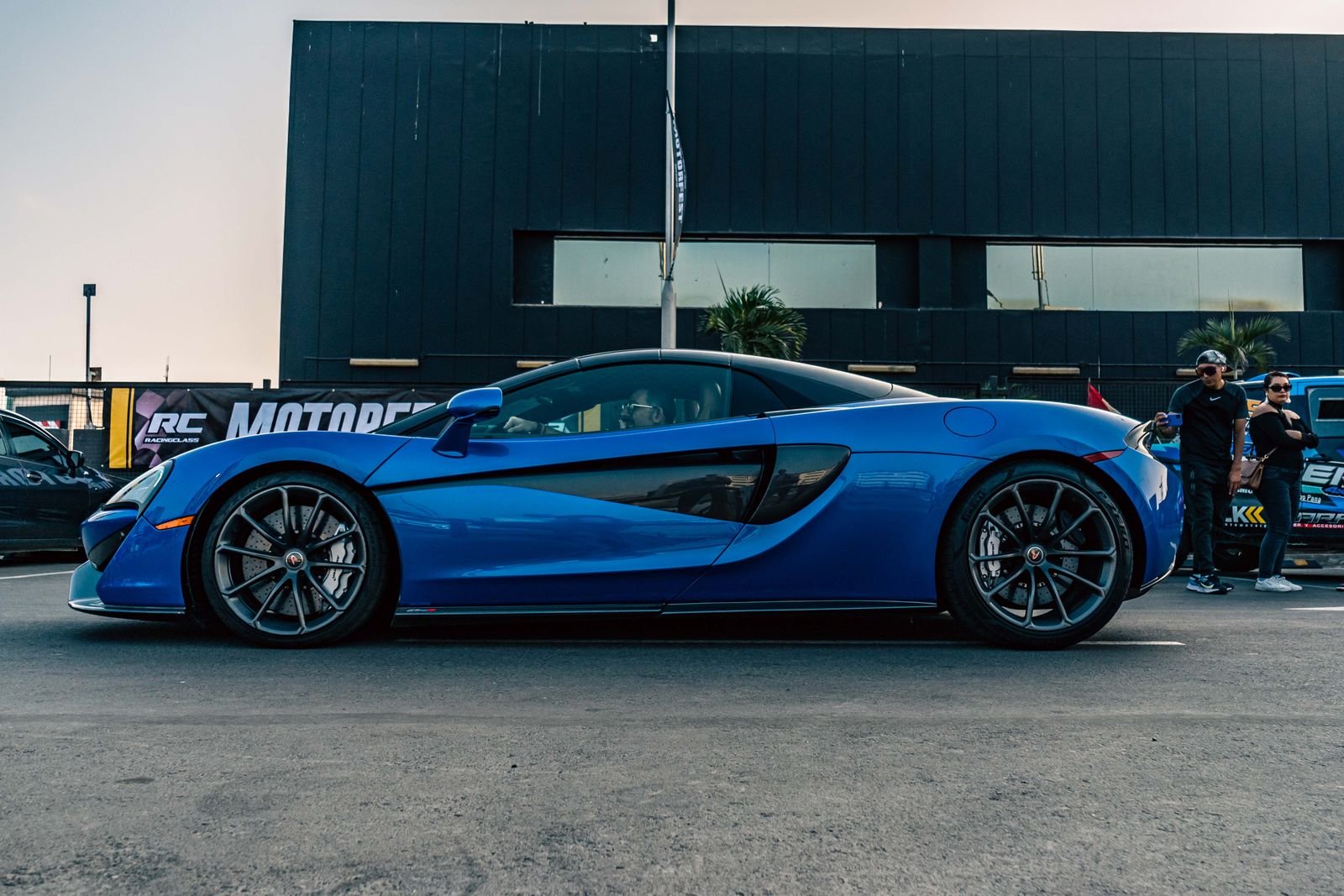 Sapphire blue McLaren sports car parked on a street, the kind of vehicle featured in Orlando exotic car rentals