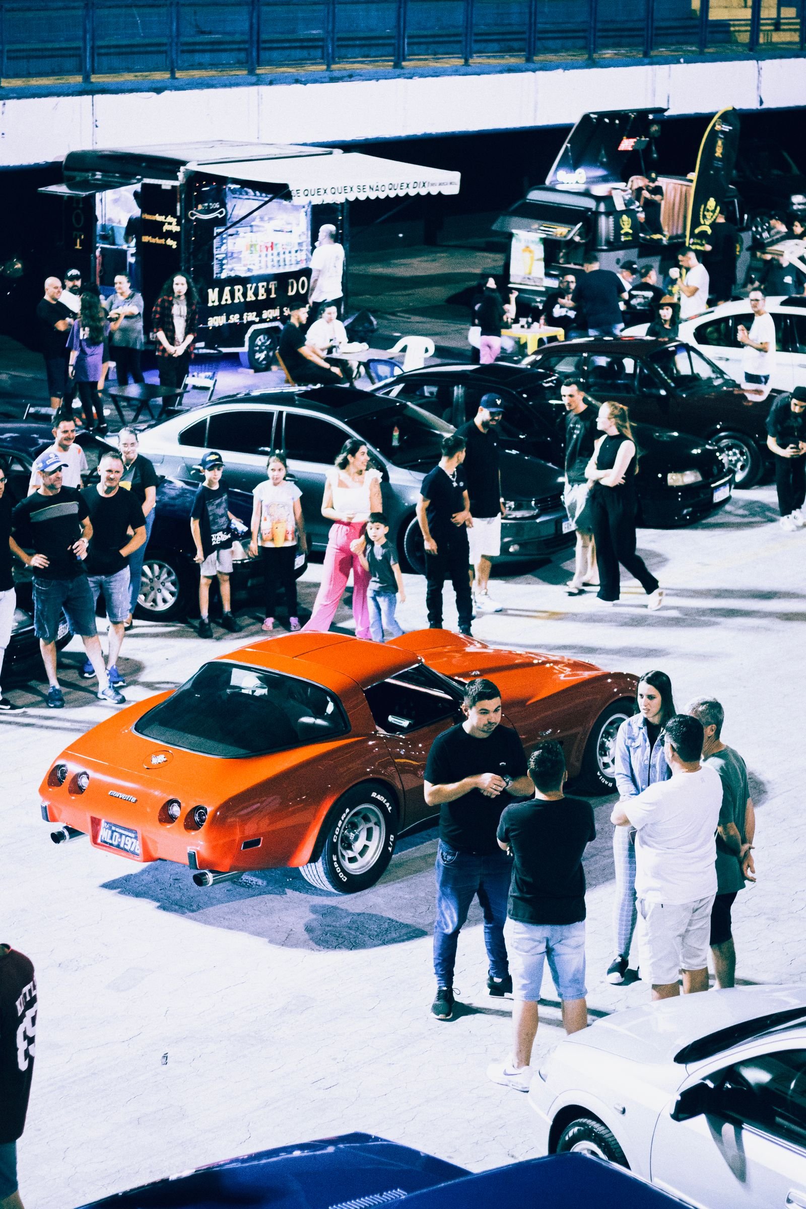 People gathered at a classic car exhibition, similar to local events performance shops in Jacksonville Florida sponsor